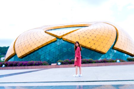 Woman Standing In Front Of Yellow And Blue Glass Building