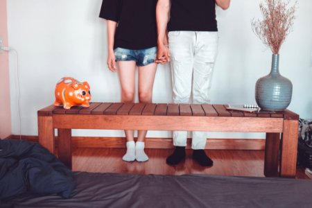 Woman And Man Holding Hand Standing Near Brown Coffee Table Inside Room photo