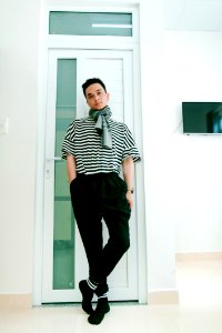 Man In Black And White Striped Shirt Leaning On Door photo