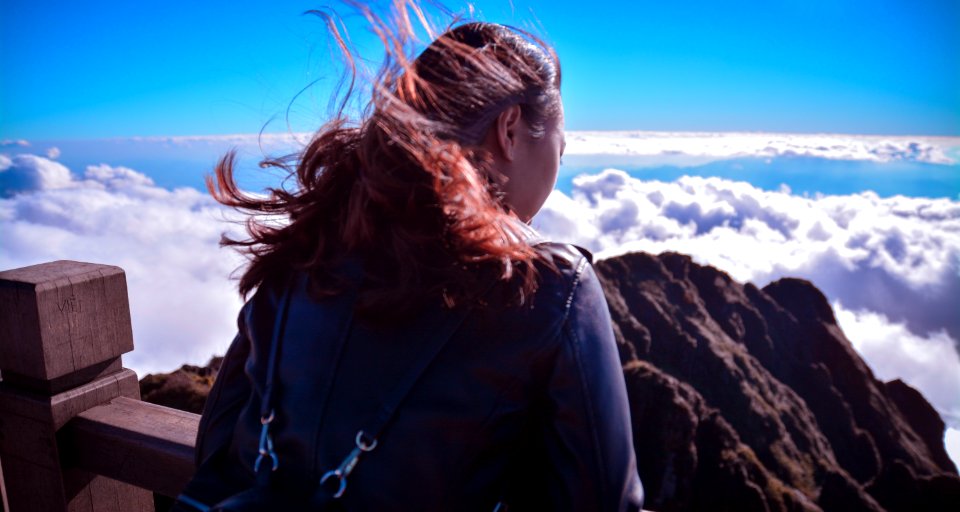 Woman Standing Near Cliff Above Clouds photo