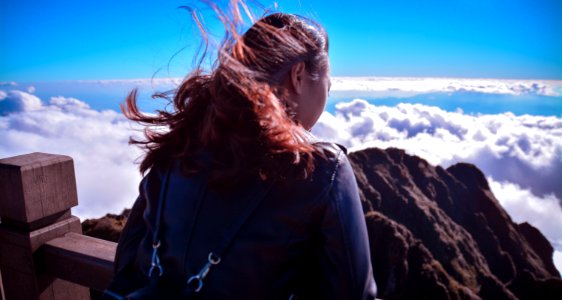 Woman Standing Near Cliff Above Clouds photo