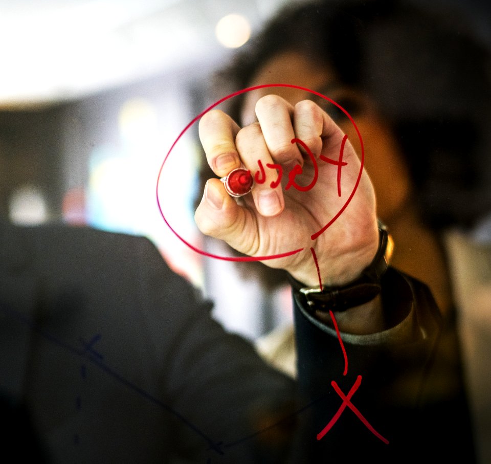 Person Wearing Black Watch Writing On Mirror Using Red Pen
