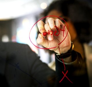 Person Wearing Black Watch Writing On Mirror Using Red Pen photo