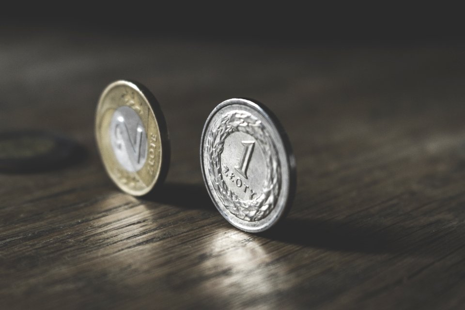 Photo Of Two Gold-colored And Silver-colored Coins Standing On Floor