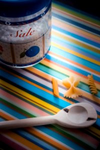 White Wooden Serving Spoon On Multicolored Textile photo