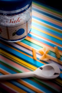 White Wooden Serving Spoon On Multicolored Textile