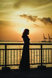 Silhouette Photo Of Woman Near Railing photo