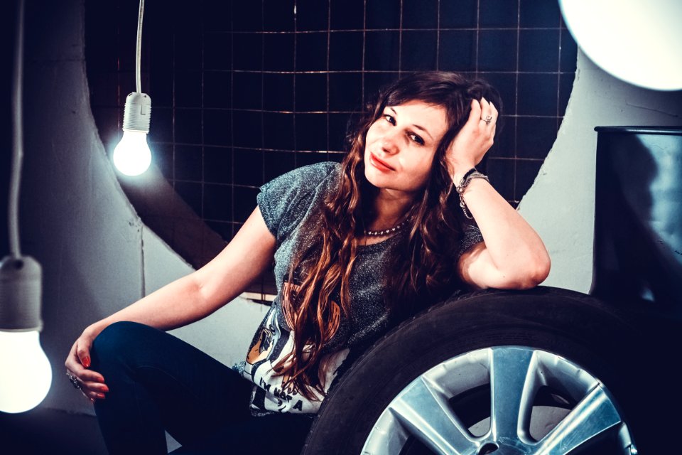 Woman In Gray Top Beside Of Wheel With Tire