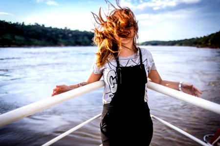 Woman Wearing Gray Shirt And Black Overalls On Boat photo