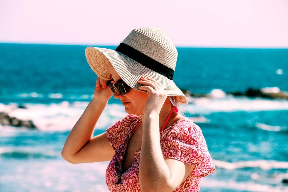 Selective Focus Photo Of Woman Wears Beige Sun Hat Stand Behind Body Of Water A Daytime