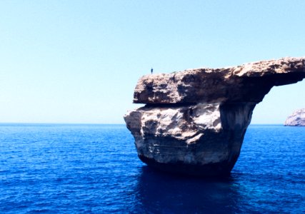 Person Standing On Rock Formation Cliff photo