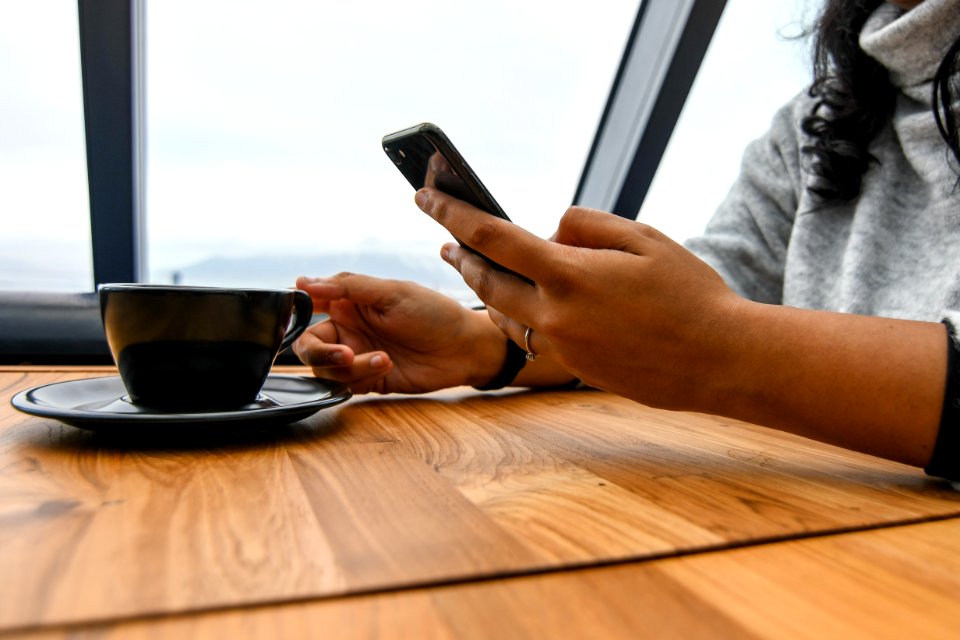 Person Holding Ceramic Cup On Table