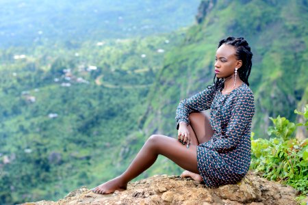 Woman Sitting On Ground Near Mountain photo