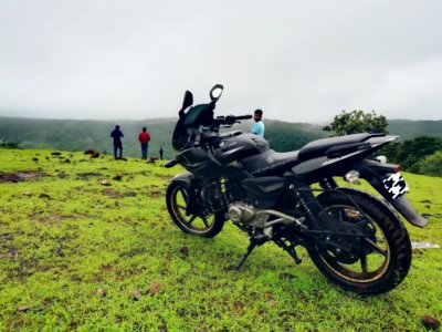 Black Backbone Motorcycle Near Man In Blue Shirt At Daytime