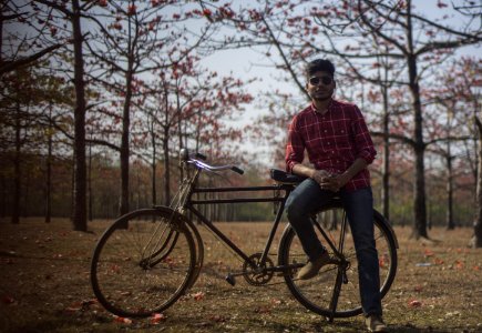 Man Wearing Red Dress Shirt And Blue Jeans Sitting On Black Bicycle photo
