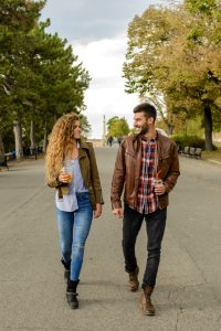 Man And Woman Wearing Brown Coats Walking On Pavement photo