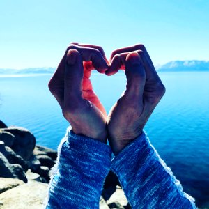 Person With Folded Hands Near Body Of Water photo