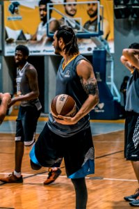 Man In Gray Sleeveless Shirt Carrying White And Brown Spalding Basketball