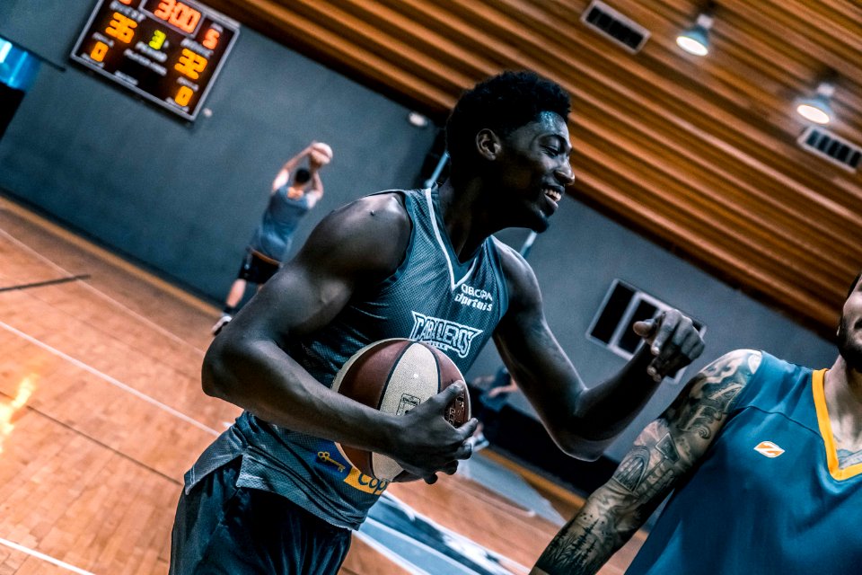 Basketball Player Holding A Brown Ball