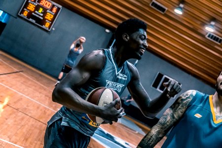 Basketball Player Holding A Brown Ball