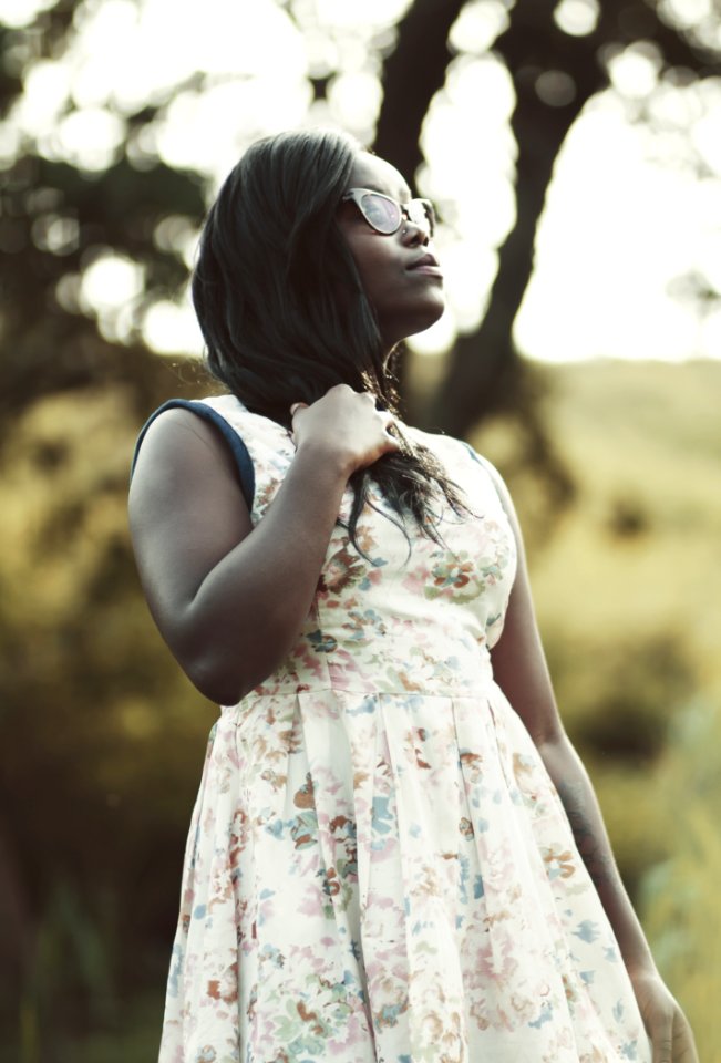 Woman Wearing White And Beige Floral Dress Holding Her Hair