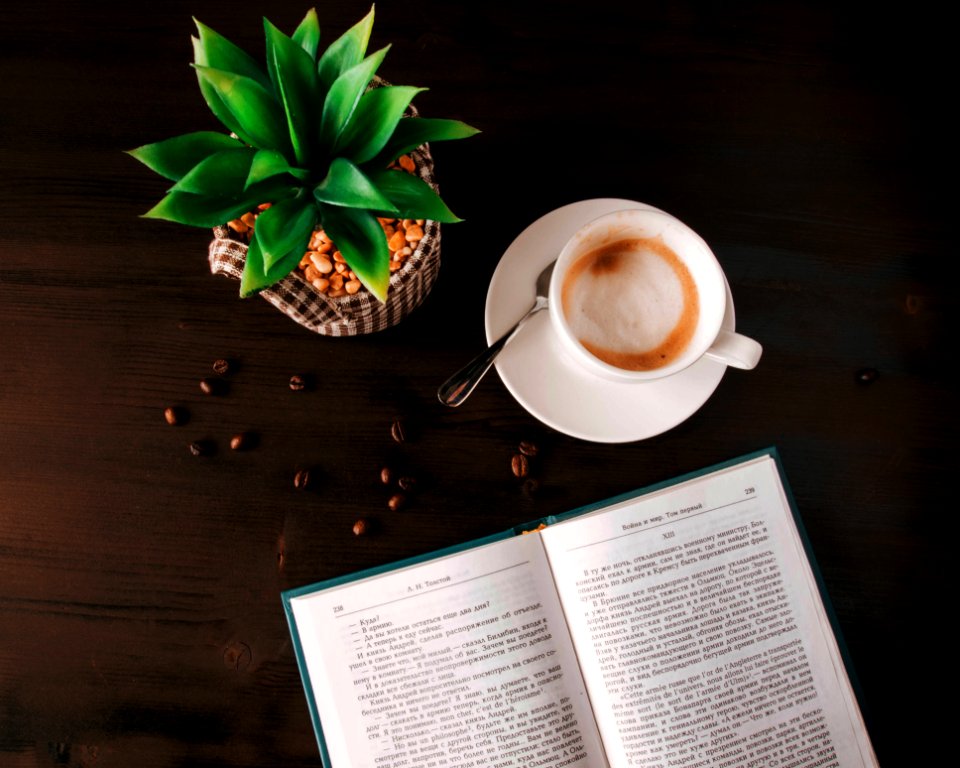 White Ceramic Mug On Saucer Near Book