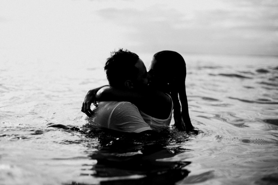 Man And Woman Kissing Together On Body Of Water photo