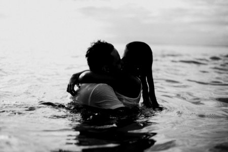 Man And Woman Kissing Together On Body Of Water photo