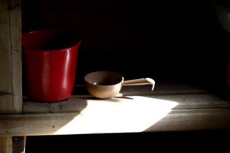 Red Bucket And Beige Dipper On Brown Wooden Table photo