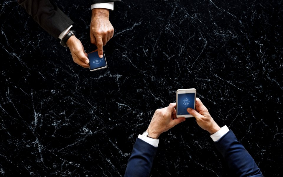 Two Person Holding White And Black Android Smartphones