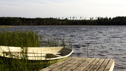 Brown Wooden Dock Beside White And Green Boat photo