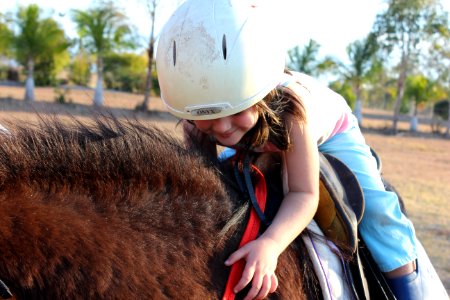 Girl In Blue Pants Riding Brown Animal