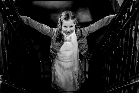 Grayscale Photo Of Girl Standing On Stairs Holding Hand Rails photo