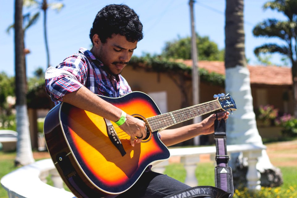 Man Holding Guitar Near Tree