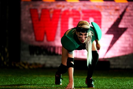 Woman In Green Shirt Crouching On Green Grass Lawn