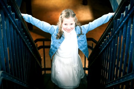 Girl Wearing White Dress And Blue Denim Jacket Standing On Stairs photo