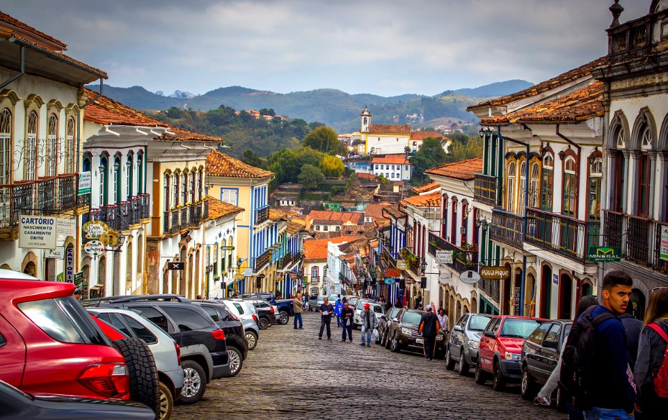 People Walking On The Streets Surrounded By Cars And Buildings
