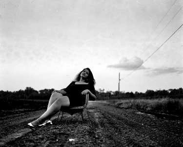 Black And White Photography Of Woman On Chair On Road photo