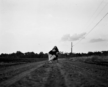 Grayscale Photography Of Woman Sits On Chair On Pathway photo