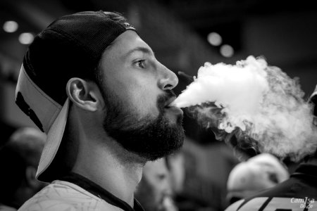 Grayscale Photography Of Man Wearing Cap With Smoke On Mouth photo