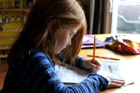 Girl Drawing On Brown Wooden Table photo