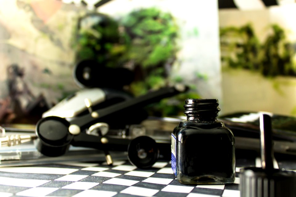 Black Glass Bottle On White And Black Checked Board