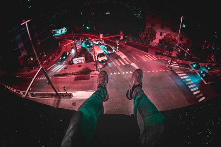 Person Sits On Building During Nighttime photo