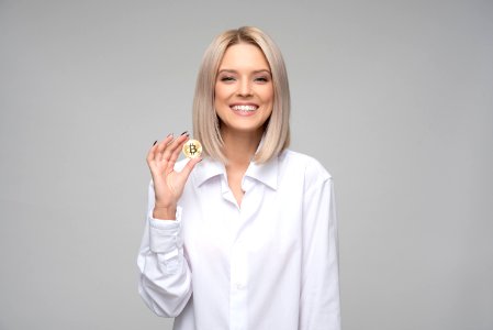 Women Wearing White Long-sleeved Collared Shirt Holding Bitcoin