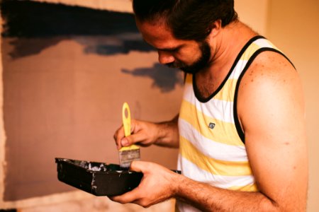 Man Holding Yellow Paint Brush photo
