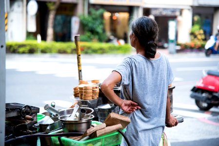 Woman Wearing Gray Shirt Standing Beside Food Cart photo