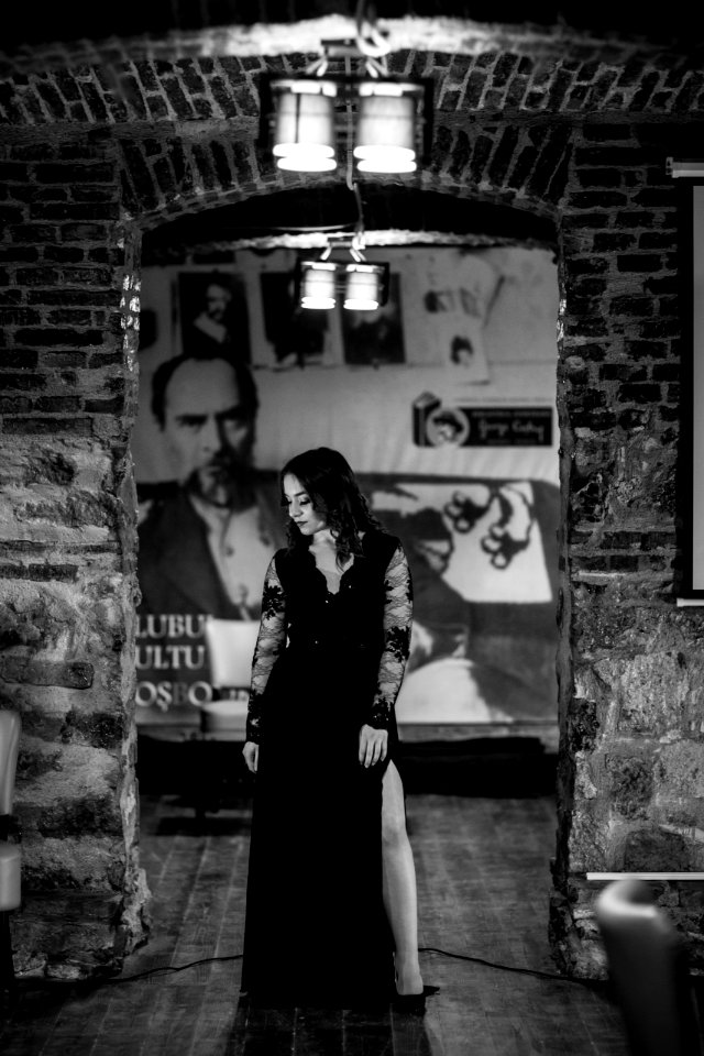 Grayscale Photography Of Woman Under Pendant Lamp