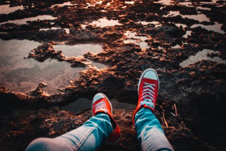 Person Wearing Red Low-top Sneakers And Jeans photo