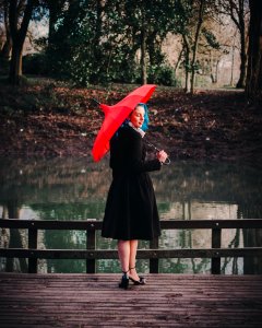 Woman Wearing Black Long-sleeved Dress Holding Red Umbrella photo