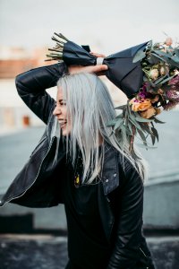 Woman Wearing Black Leather Jacket Holding Flower Bouquet photo